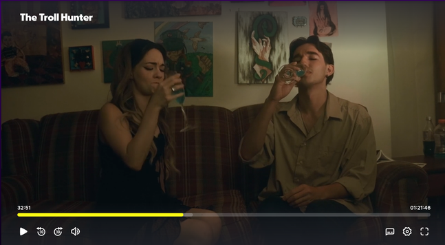 People drink in front of wall art 
